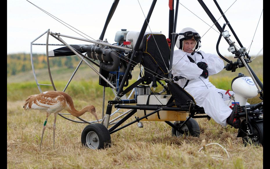 Russian President Vladimir Putin looks at a crane as he sits in a motorised deltaplane at Yamalo-Nen