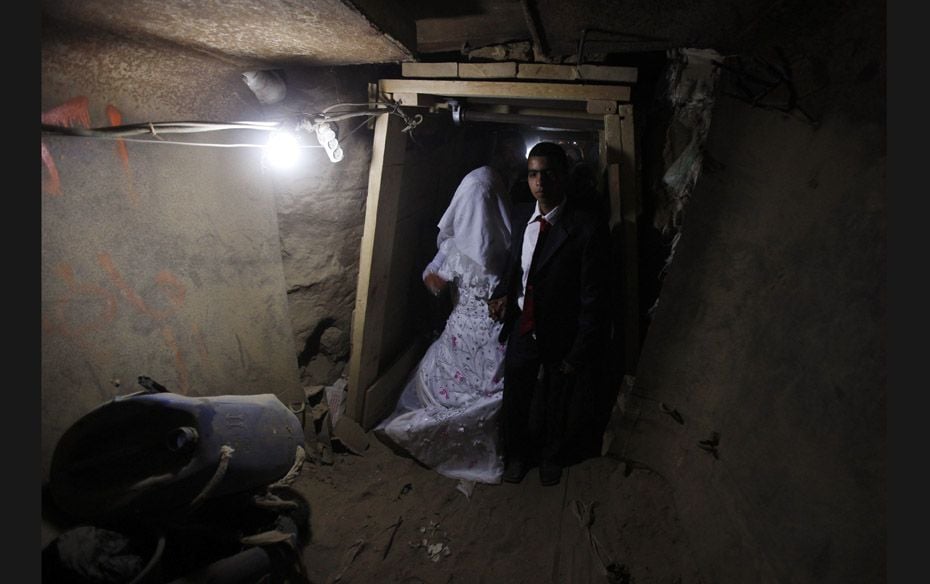 Palestinian groom Emad al-Malalha, 21, walks with Manal Abu Shanar, 17, his Egyptian bride, inside a