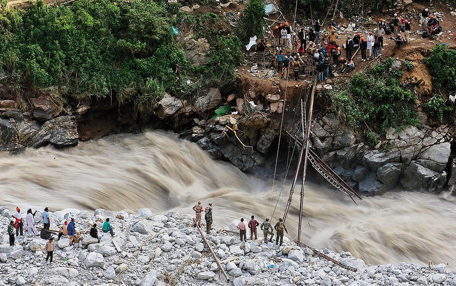 Soldiers try to repair a temporary footbridge over river Alaknanda after it was destroyed during res