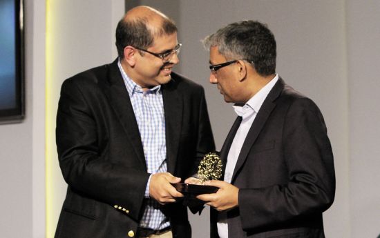 Amit Chandra of Bain Capital receives the NextGen Leader in Philanthropy Award from Ravi Ventakesan 