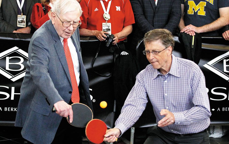 Berkshire Hathaway CEO Warren Buffett (left) tries his hand at table tennis along with Microsoft Cha