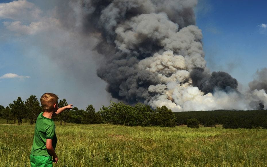 Seven-year-old Floyd Kerr Jr of Colorado Springs is watching the smoke cover Black Forest area on Ju