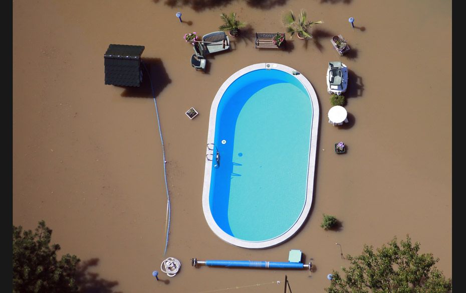 A garden with a swimming pool is inundated by the waters of the Elbe River during floods near Magdeb