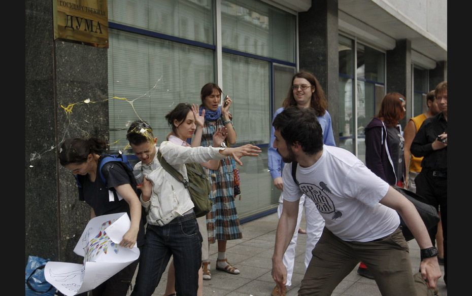 A radical Orthodox believer (R) throws an egg at gay rights activists during a protest against a pro