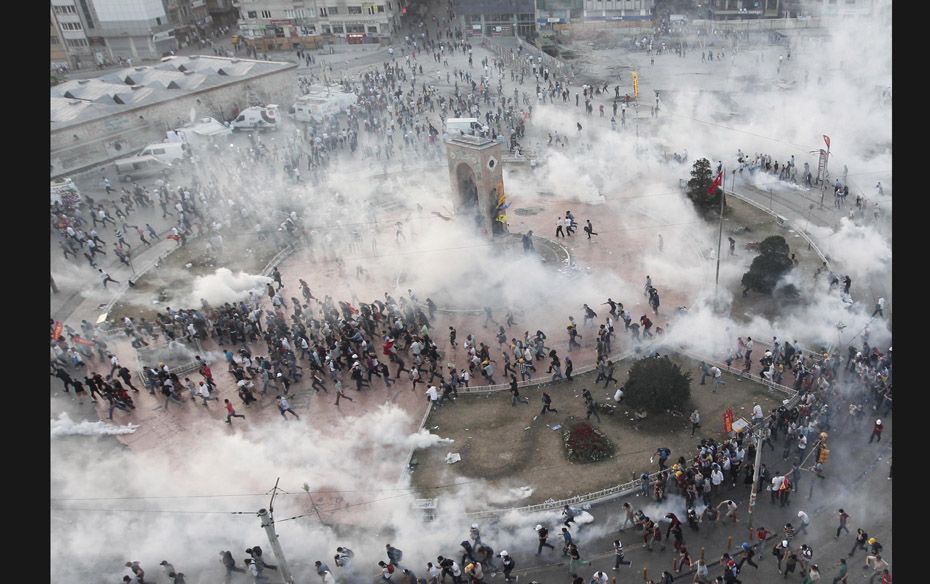 Protesters run as the riot police fires teargas during a protest at Taksim Square in Istanbul on Jun