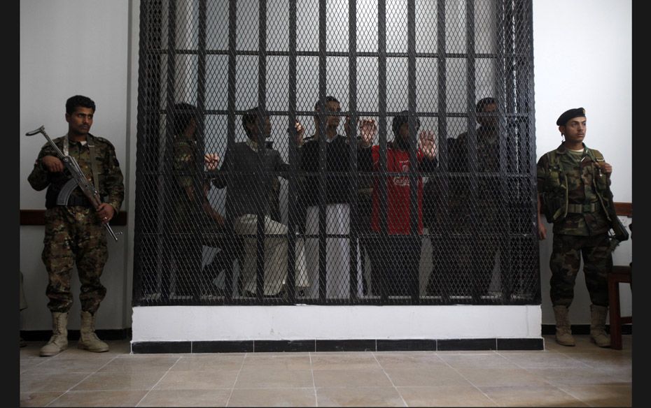 Police troopers stand guard outside a holding cell where Al-Qaeda suspects were held during a hearin