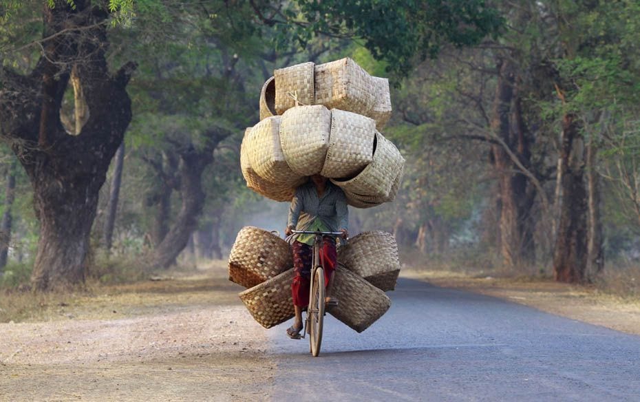 A woman cycles as she carries baskets to sell in a market near Lapdaung Mountain in Sarlingyi Townsh