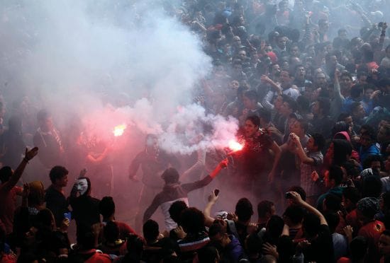 Egyptian Al-Ahly football team supporters light flares as they celebrate  in Cairo on March 9, after