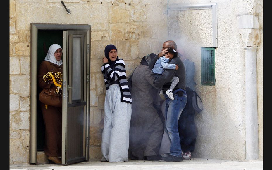 Palestinians react to tear gas fired by Israeli police during clashes on March 8, after Friday praye