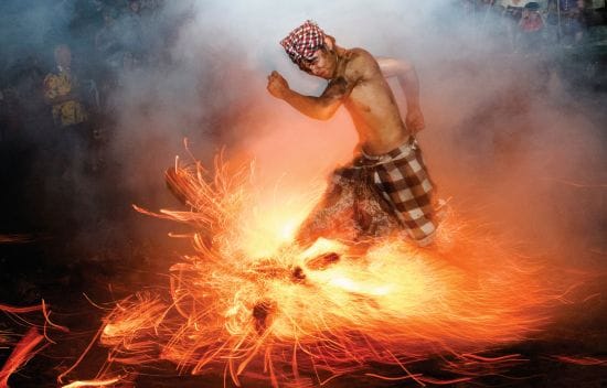 A Balinese man kicks up fire during the Perang Api ritual ahead of Nyepi Day in Gianyar on the Indon