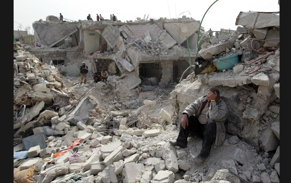 A dejected man sits in the midst of rubble at a site hit by what activists said was a Scud missile i