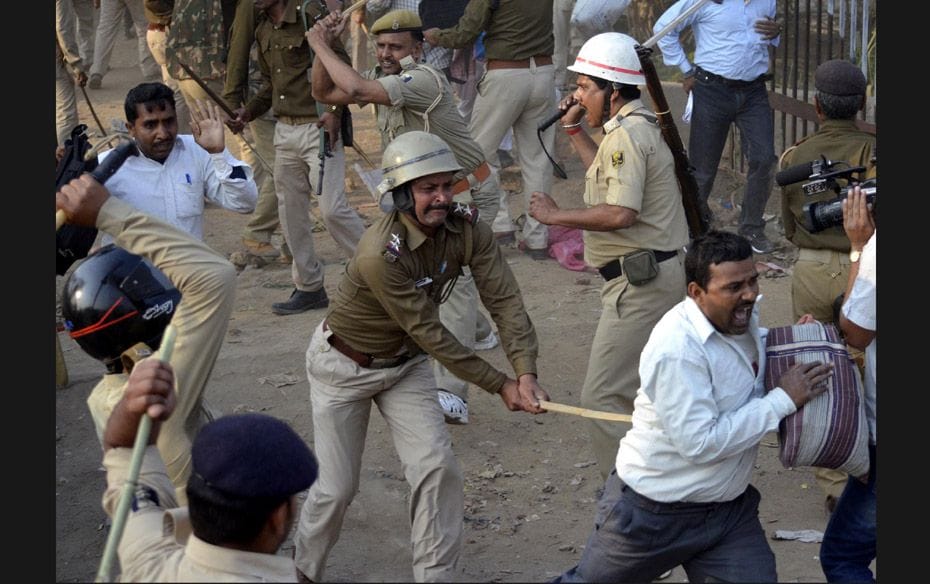 Police wield their batons against teachers during a protest in the Indian city of Patna on March 5. 