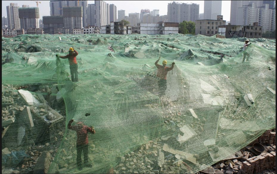 Workers set up dust screen on a demolition site in Xi'an, Shaanxi province on April 27. Accordin