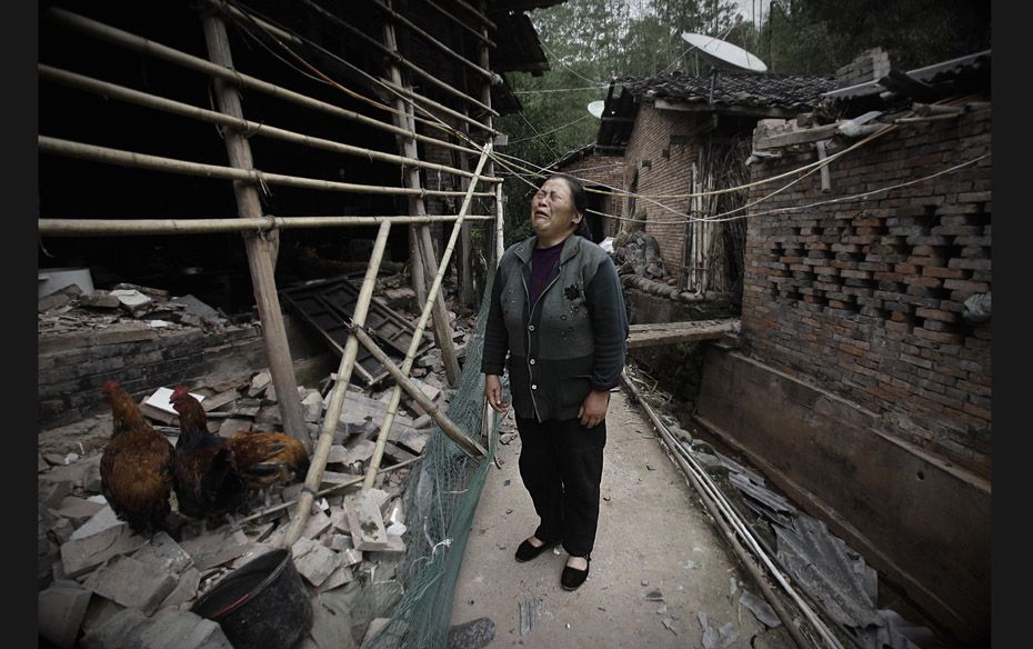 A woman cries amongst collapsed houses in Ya'an, Sichuan province on April 22. Hundreds of survi