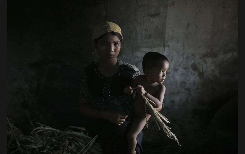 Hla Hla May, a Rohingya Muslim woman displaced by violence, holds her one-year old daughter Roshan a