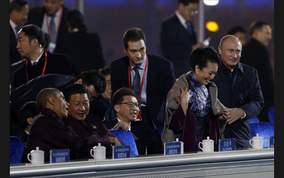 Russia's President Vladimir Putin (R) helps put a blanket on Peng Liyuan (second from right), wi