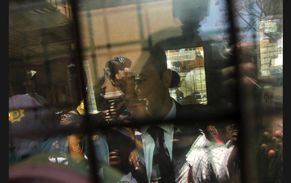 South African Olympic and Paralympic sprinter Oscar Pistorius inside a police van on October 21 afte