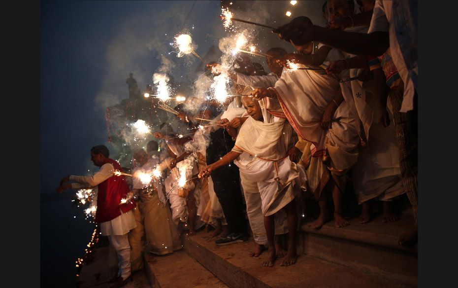 Widows, who have been abandoned by their families, light sparklers after offering prayers on the ban