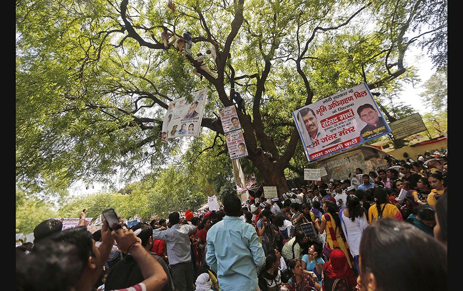 Supporters of Aam Aadmi (Common Man) Party (AAP) watch as others try to rescue a farmer who hung him