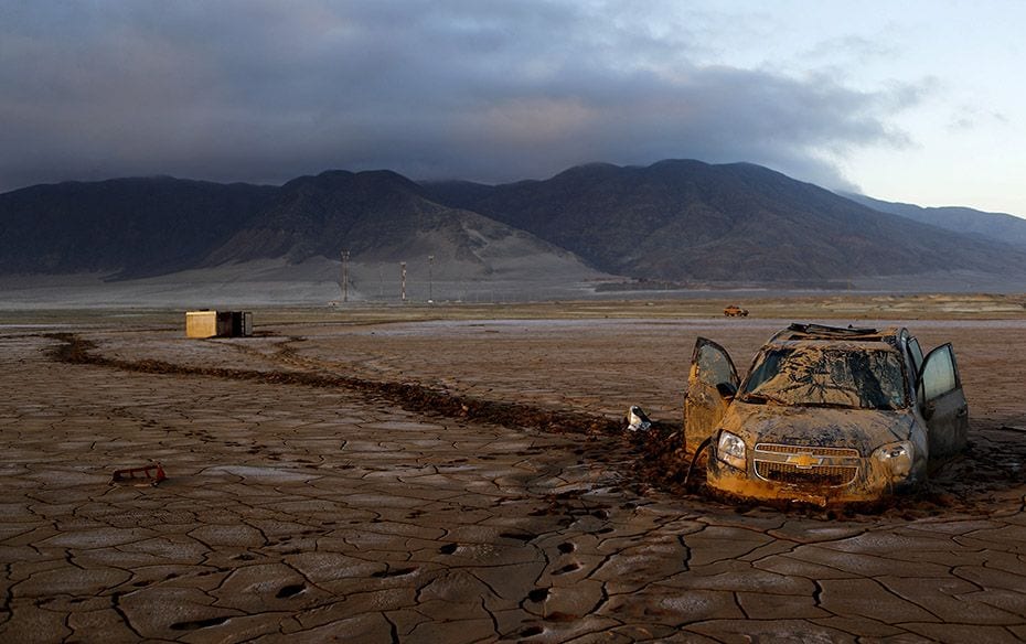 A vehicle partially submerged in dry mud, in an area that was hit by floods at Chanaral town, April 