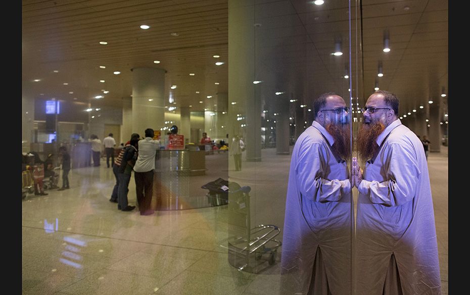 A man waits for his family who were evacuated from Yemen at the international airport in Mumbai, Apr