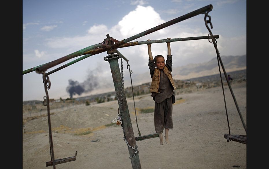 An Afghan boy plays on a merry-go-round on a hill top in Kabul on July 20. Kabul was rocked by separ