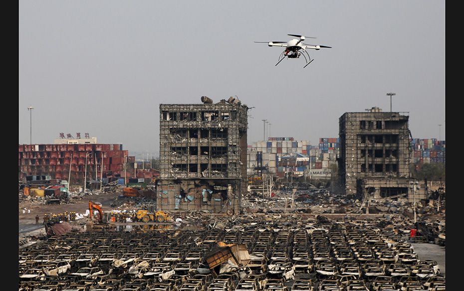 A drone operated by paramilitary police flies over the site of explosions in Binhai new district in 