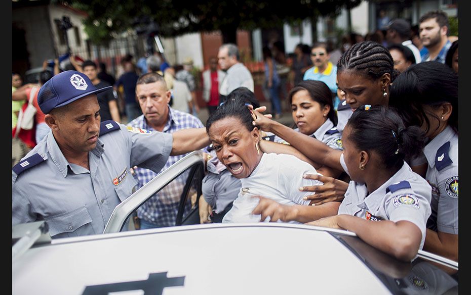 Cuban security personnel detain a member of the Ladies in White dissident group during a protest on 