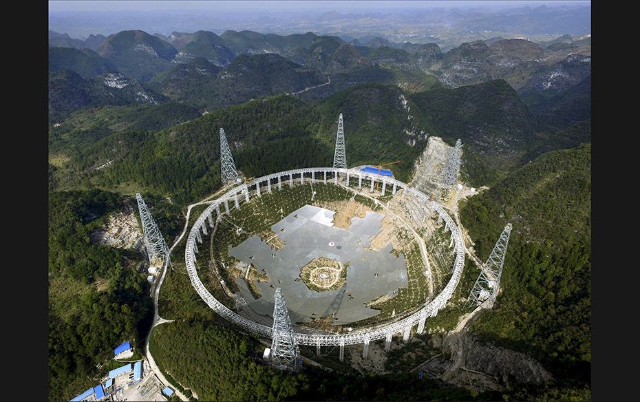 The Five-hundred metre Aperture Spherical Telescope (FAST) is seen under construction among the moun