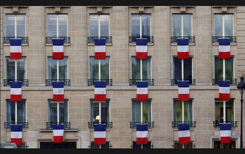 French flags hang from windows of a building near the Invalides in Paris on November 27. The French 