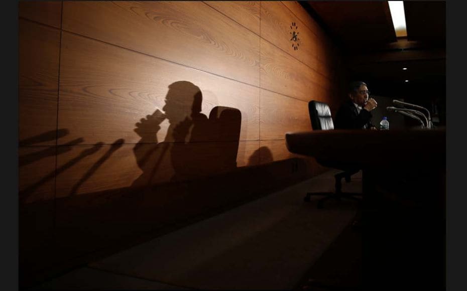 Bank of Japan (BOJ) Governor Haruhiko Kuroda drinks water during a news conference at the BOJ headqu