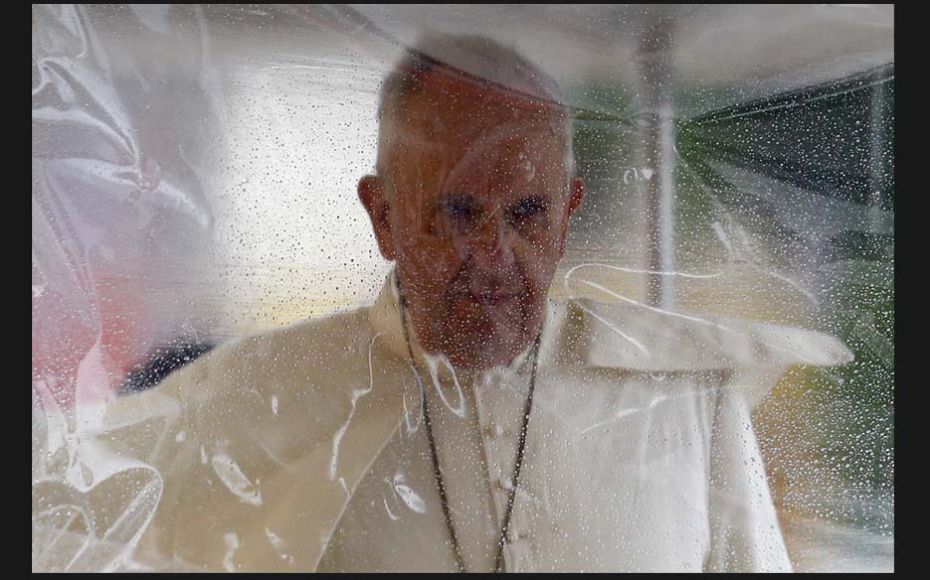 Pope Francis is seen through a plastic cover as he arrives to visit Palo Cathedral near Tacloban air