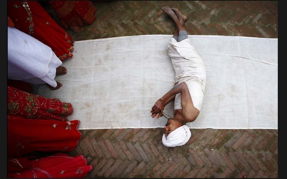 A devotee offers prayers by rolling on the ground at Sankhu during the Swasthani Brata Katha festiva