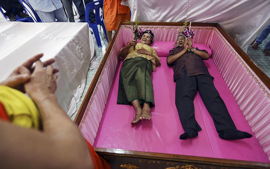 A groom and a bride lay inside a pink coffin during their wedding ceremony at Wat Takien temple in N