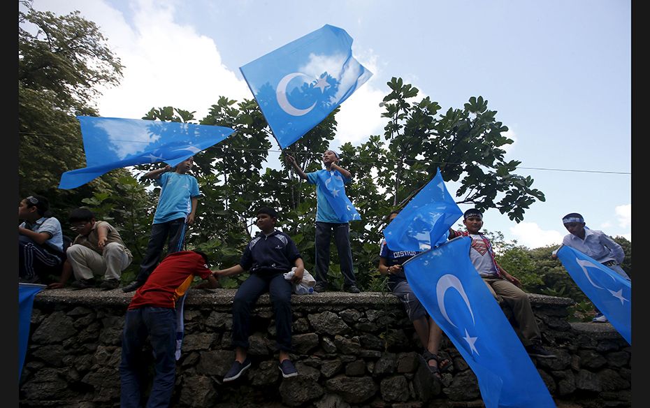 Boys wave East Turkestan flags during a protest against China near the Chinese Consulate in Istanbul