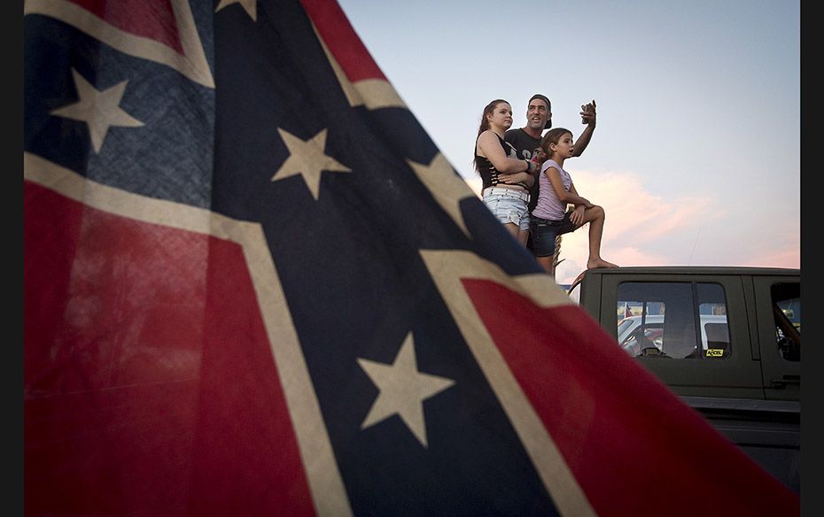 A family stands on the back of their pick-up truck as they take part in the ‘Ride for Pride&rs