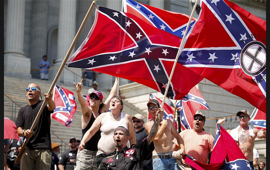 Members of the Ku Klux Klan yell as they fly Confederate flags during a rally at the statehouse in C