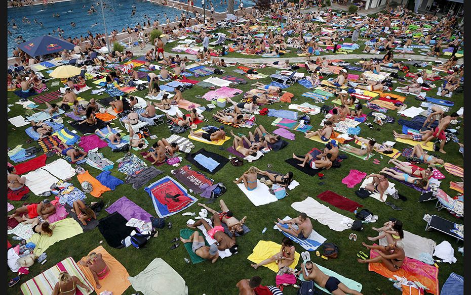 People relax at the public swimming pool of Schoenbrunner Bad on a sunny day in Vienna, Austria, on 