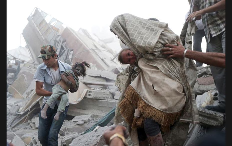 Men hold children rescued from under the rubble at a site hit by, what activists said, was heavy she