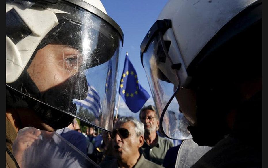 Riot policemen stand between anti-austerity and pro-European Union protesters in front of the parlia