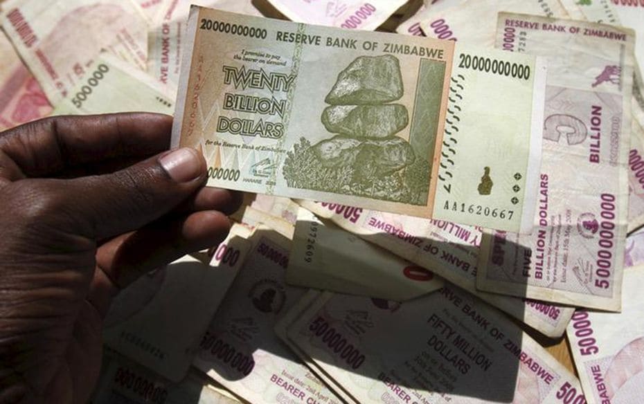 A man poses with a Zimbabwean bank note at a bank in central Harare on June 15, 2015. Zimbabweans ar