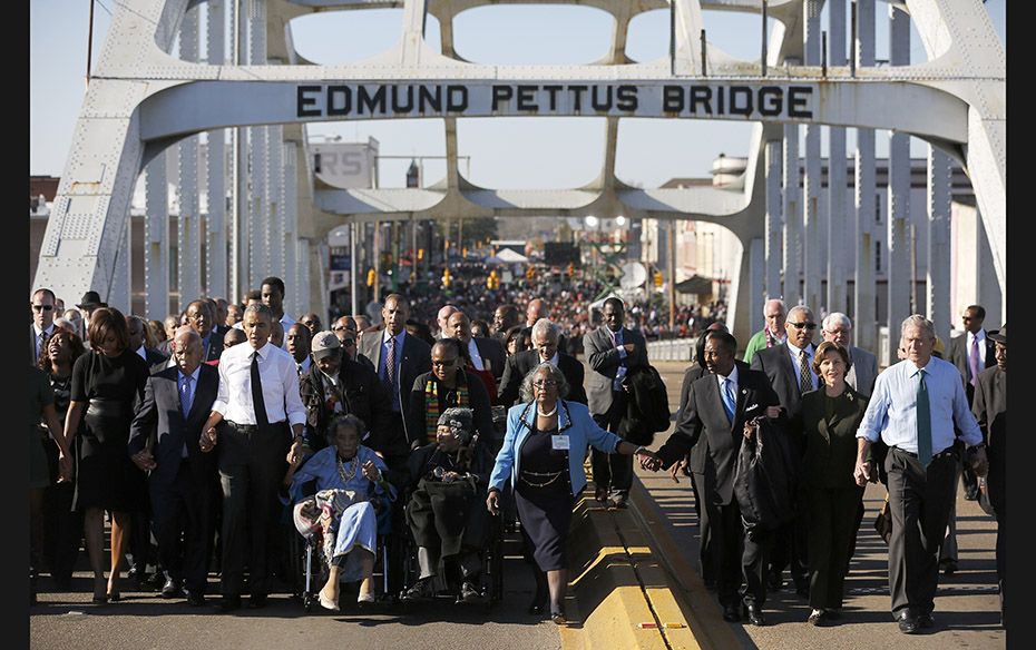 US President Barack Obama (third from left) and wife Michelle participate in a march across the Edmu