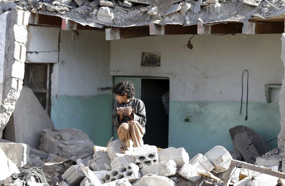 A boy sits at the site of an air strike in a residential area near Sanaa Airport on March 26. Saudi 