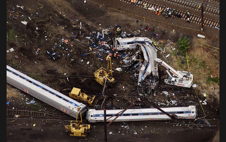 Emergency workers look through the remains of a derailed Amtrak train in Philadelphia, Pennsylvania,