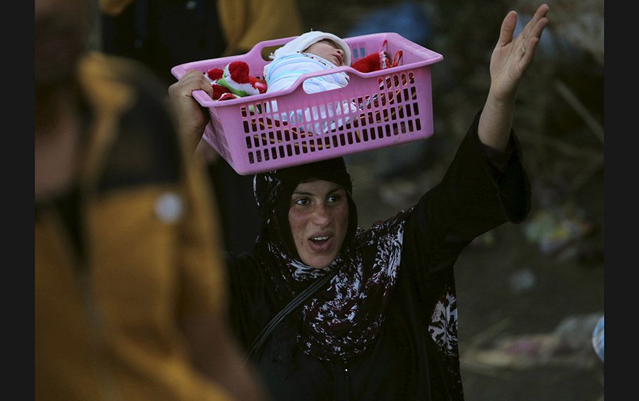 An Iraqi Sunni displaced woman, who fled from the violence in the city of Ramadi, carries her child 