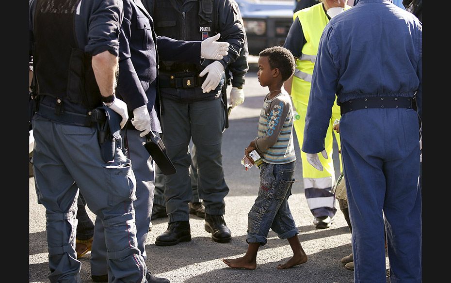 A child walks barefoot after getting off a tug boat in the Sicilian harbour of Pozzallo on May 4. It