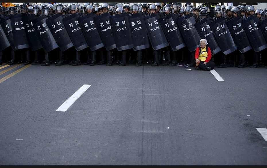 An elderly protester is blocked by a barricade of policemen during an April 24 rally in central Seou