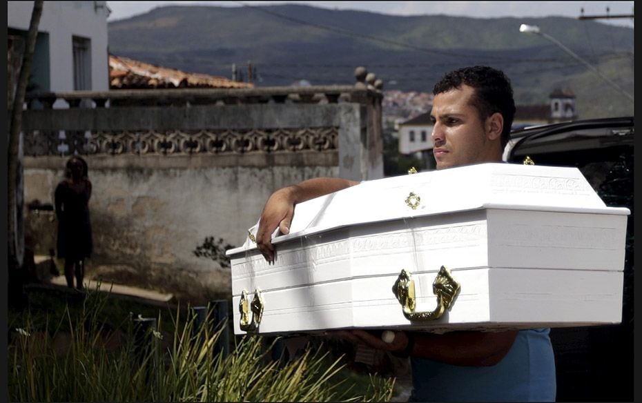 A man carries the coffin of Emanuele Vitoria Fernandes, 5, who died in Bento Rodrigues district afte