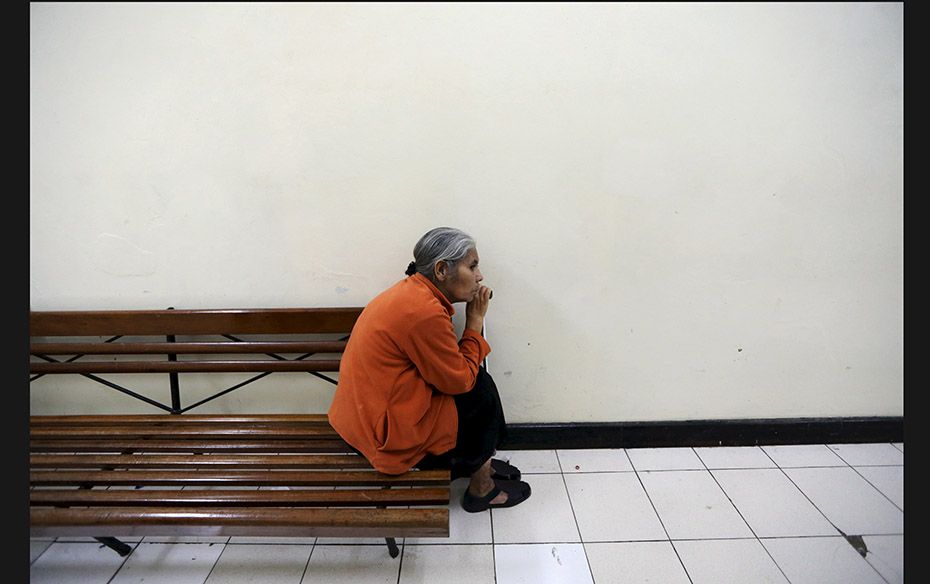 A woman sits outside an outpatient clinic at the Roosevelt Hospital in Guatemala City after it was c