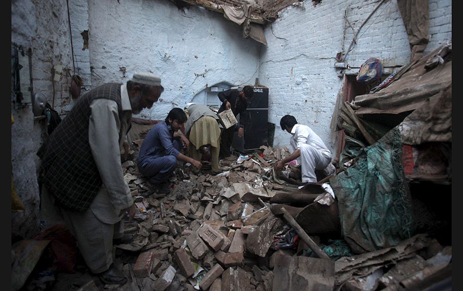 Residents search for belongings amidst rubble as several houses in Pakistan’s Peshawar collaps